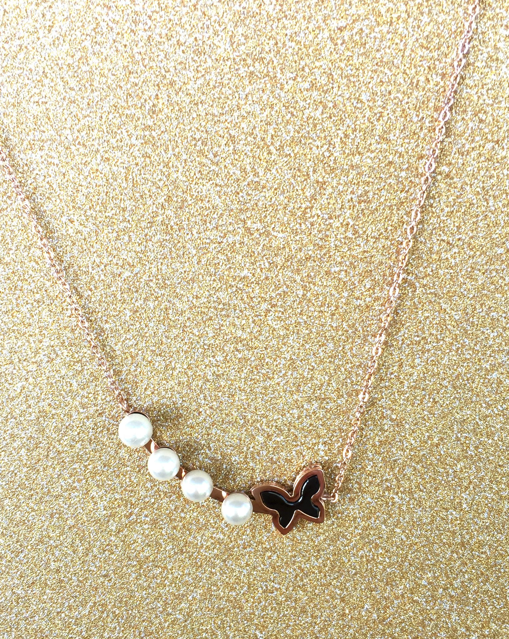 A beautiful butterfly pendant made of mother of pearl and emblazoned with small glittering crystals on a gold metal base. J020010